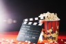 blank-clapperboard-leaning-against-popcorn-bucket 23-2147698985